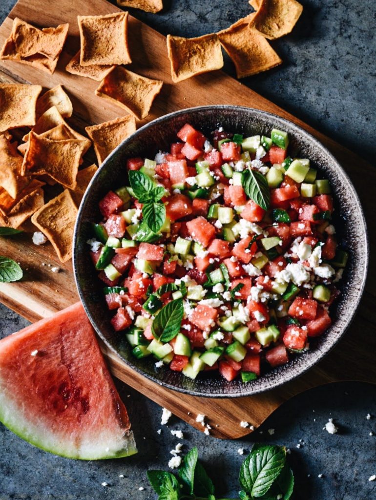 a bowl of watermen salad with chips in the background