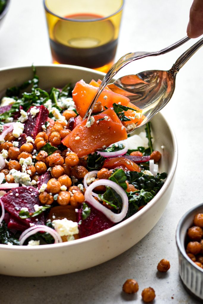 Side view of the finished salad with kale, roasted chickpeas, roasted beets, feta cheese.