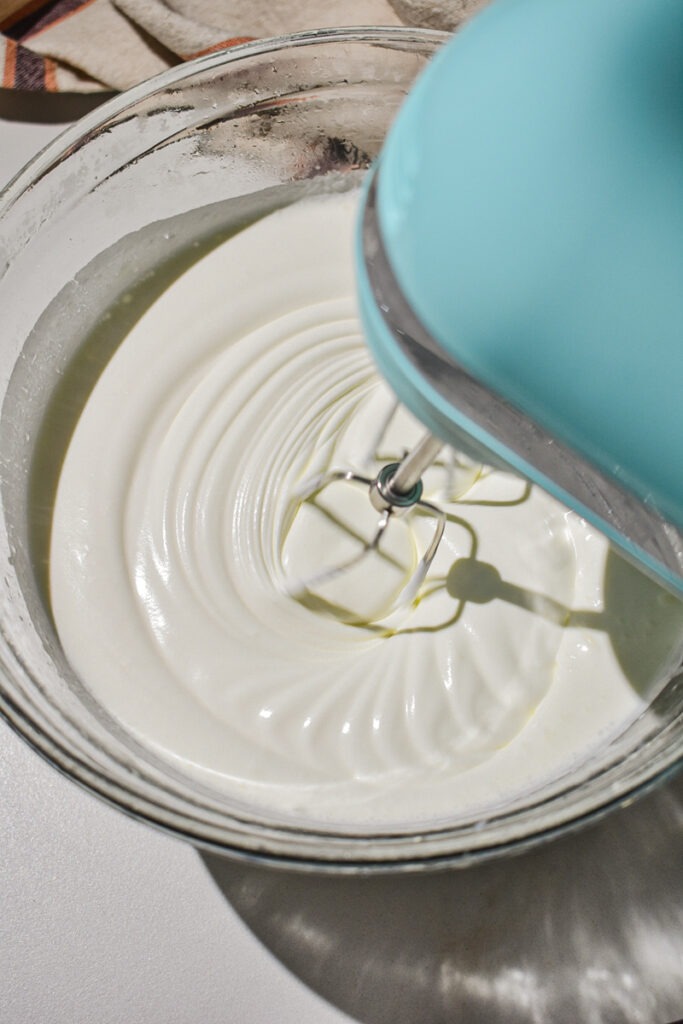 Using a hand mixer to whip up heavy cream.