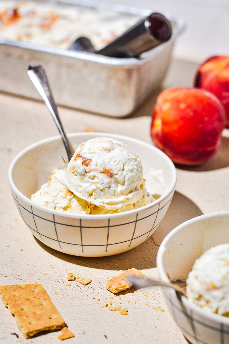 Cardamom peach cobbler no churn ice cream served in a bowl with a spoon.