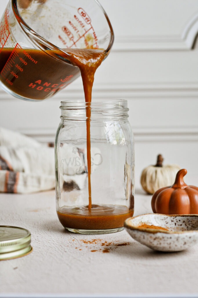 Pouring the pumpkin sauce in a jar.