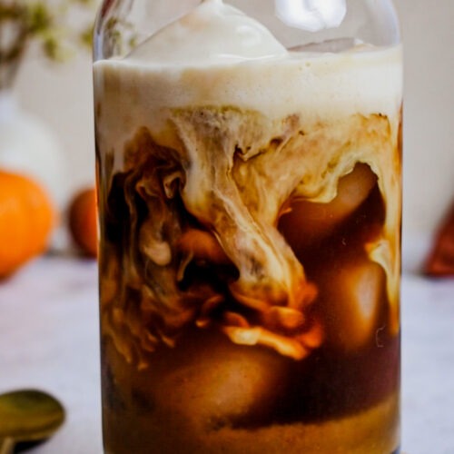 Pouring milk into a homemade pumpkin spice latte.