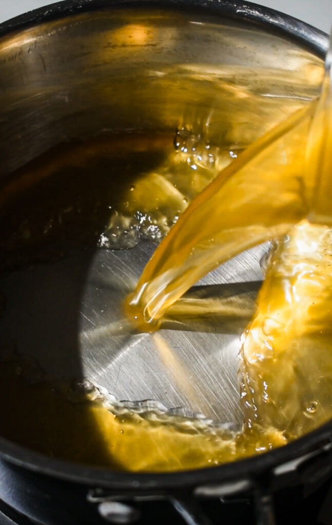 Pouring broth into a pot to heat up.