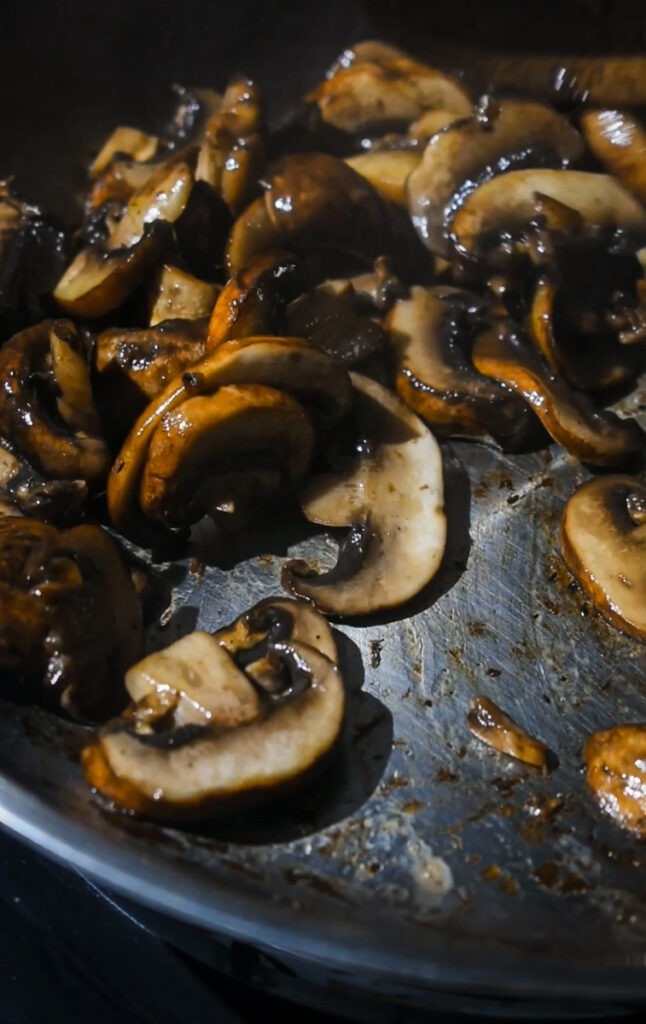 Sautéing mushrooms in a skillet.