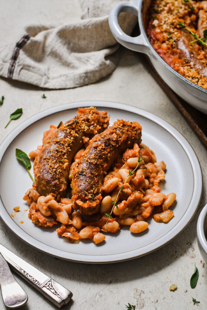 Side view of white bean and sausage cassoulet portion on a plate.
