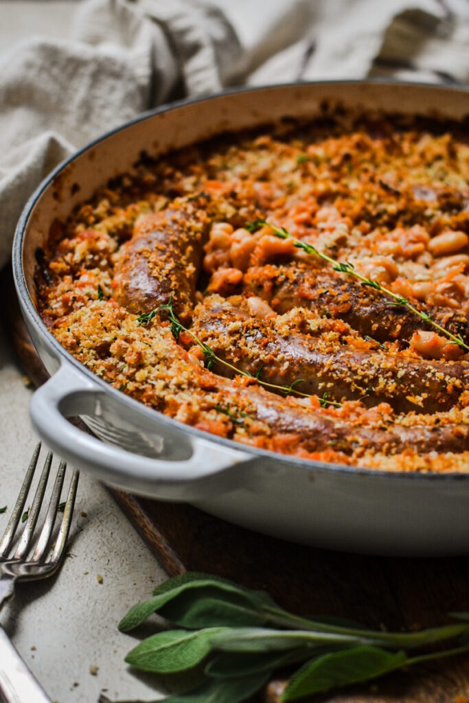 Side view of white bean and sausage cassoulet in a Dutch oven skillet.