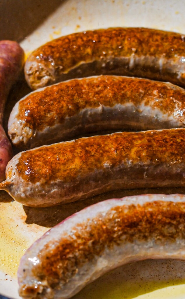 Sautéing sausages in a skillet.