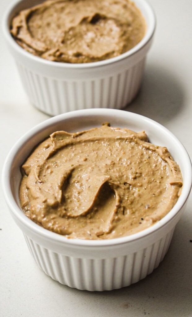 Chicken liver pate placed in white ramekins to chill.