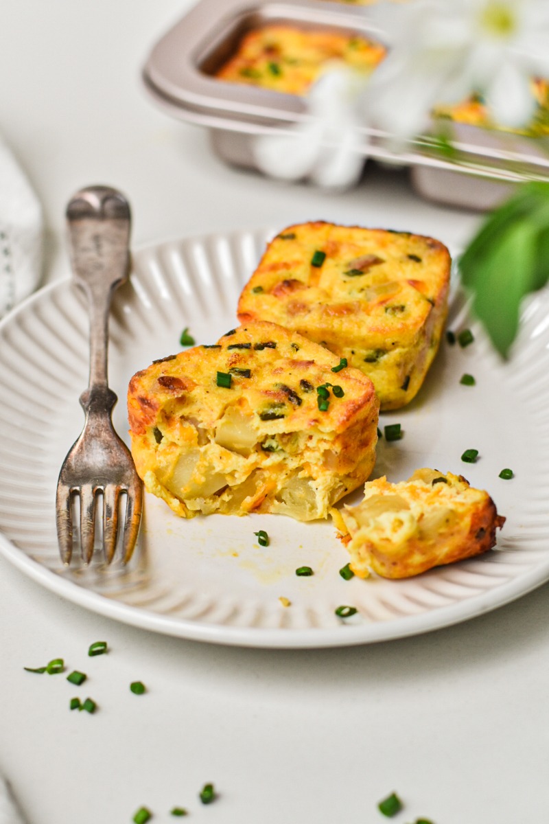 Starbucks Potato, cheddar and chive bakes on a plate with one with a piece broken off.