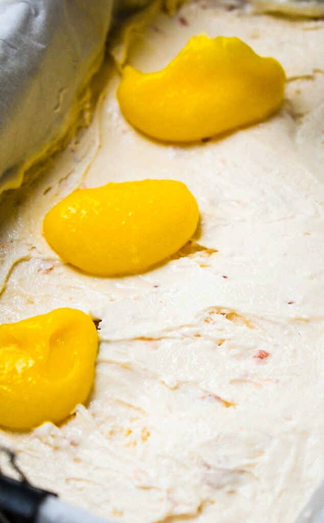 Lemon curd on top of the ice cream layer in a loaf pan.