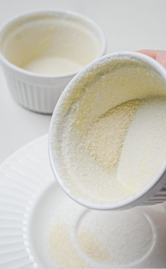 Coating a ramekin with butter and sugar.