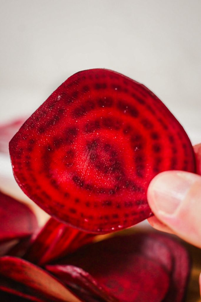 vibrant red thin slice of raw beetroot