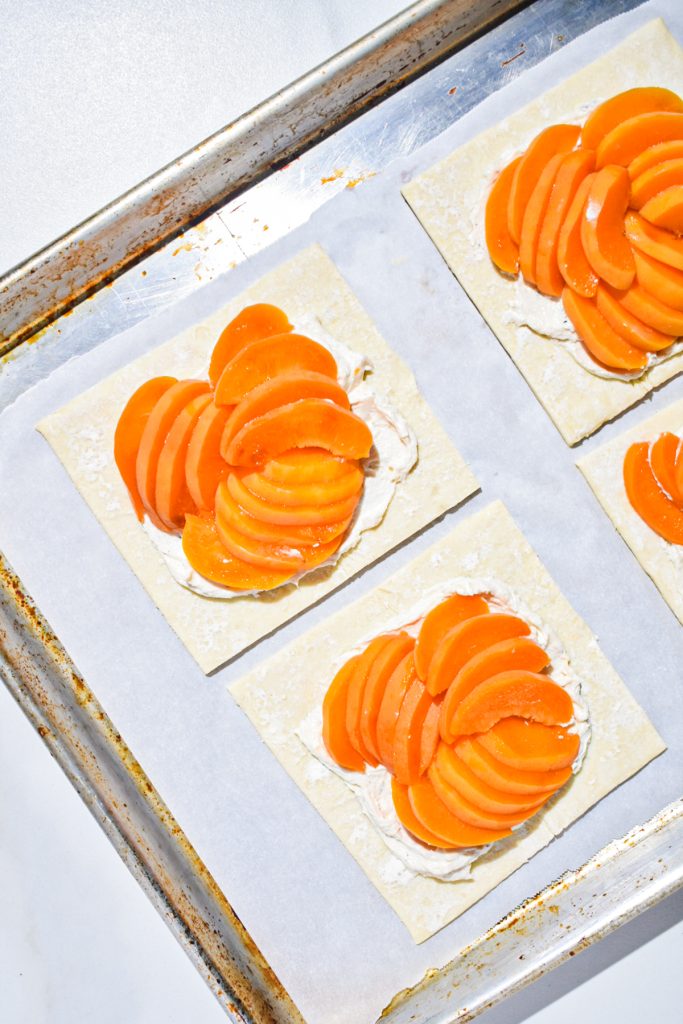 goat cheese mixture with apricot slices spread on each square leaving 1/2” around