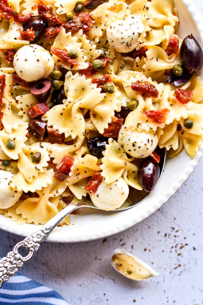 Close up shot of Italian bow tie pasta salad in a serving bowl.