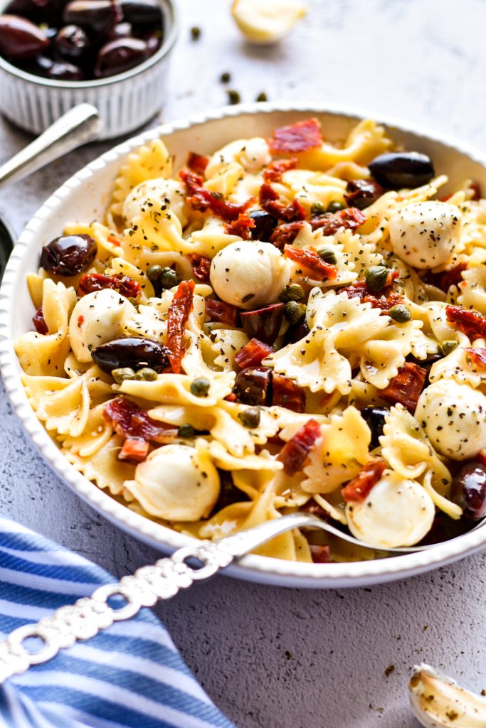 Farfalle pasta salad mixed together and served in a white serving bowl.