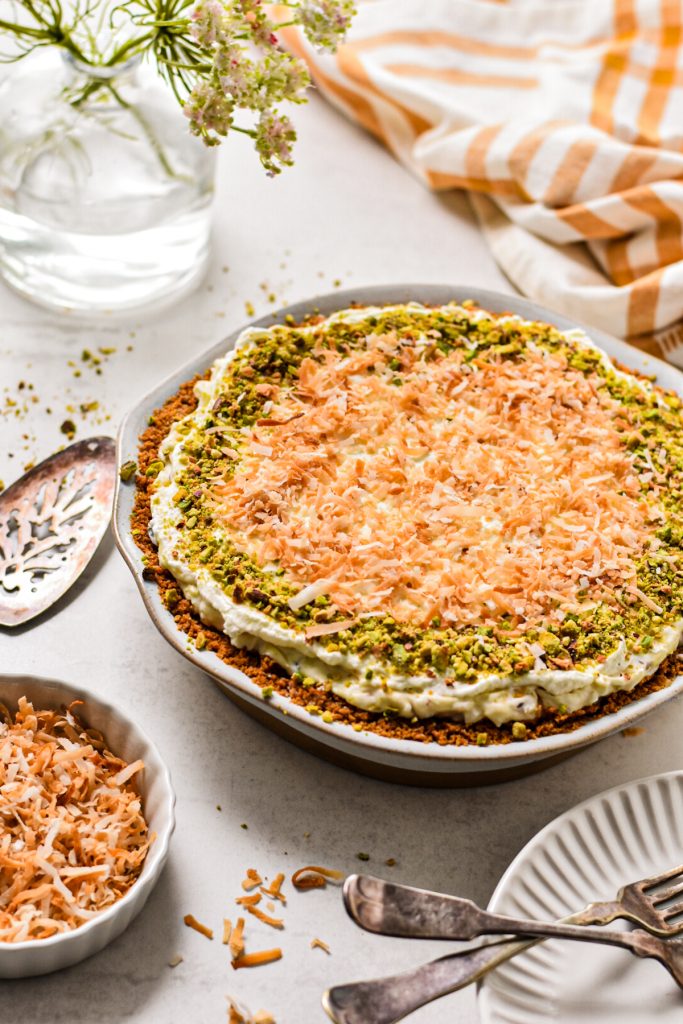 Million dollar pie decorated with toasted coconut and chopped pistachios.