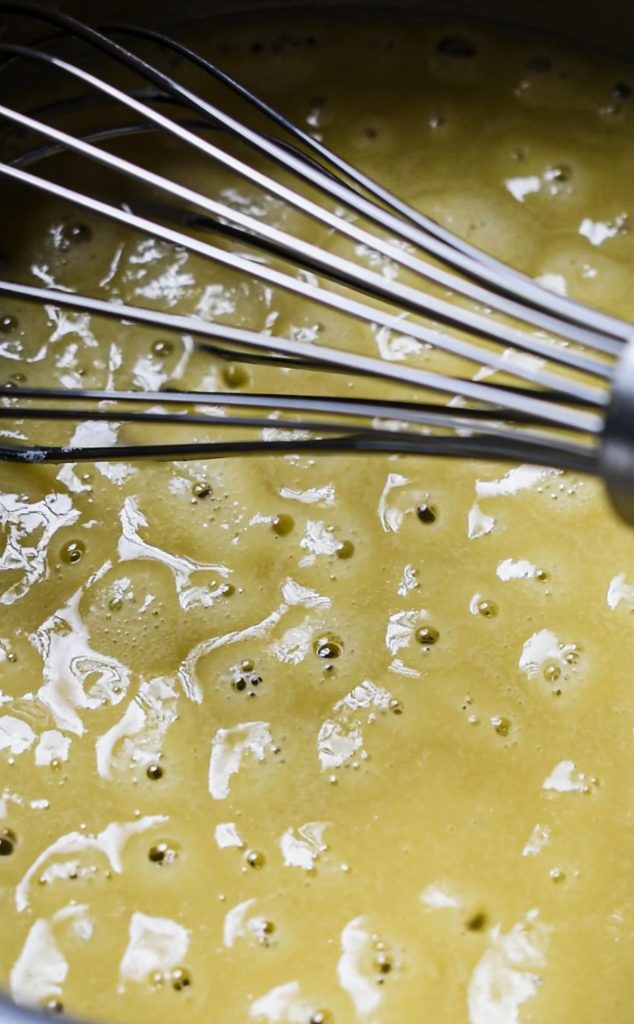 Butter and flour cooking in a skillet with a whisk.