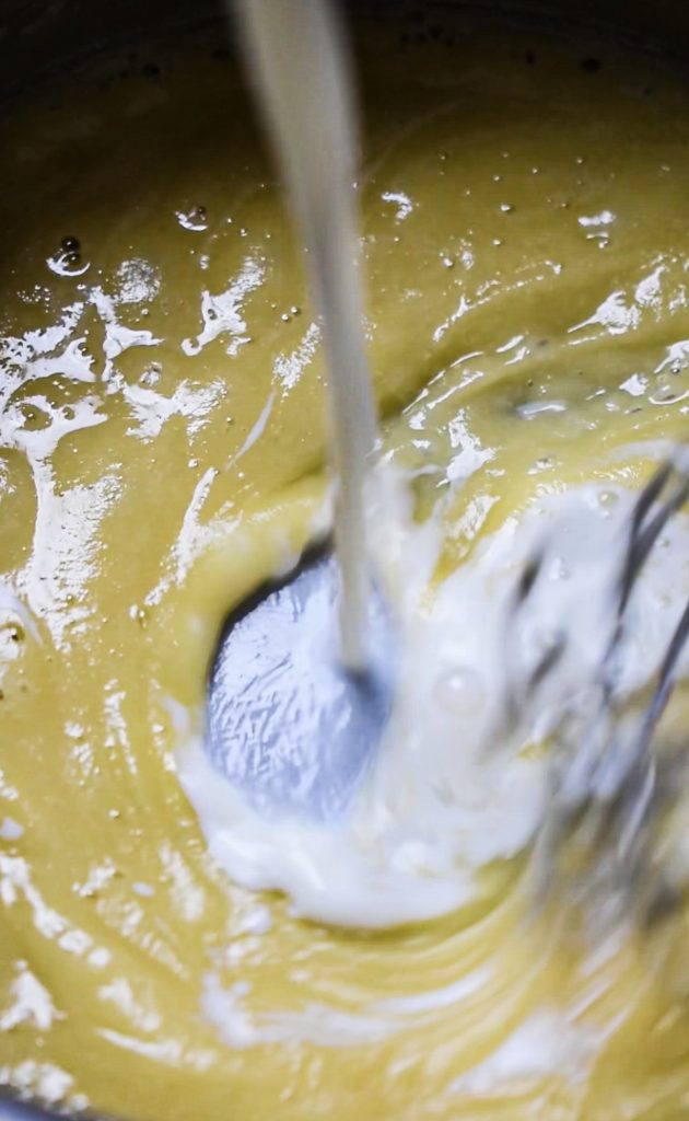 Milk being poured into the butter and flour mixture.