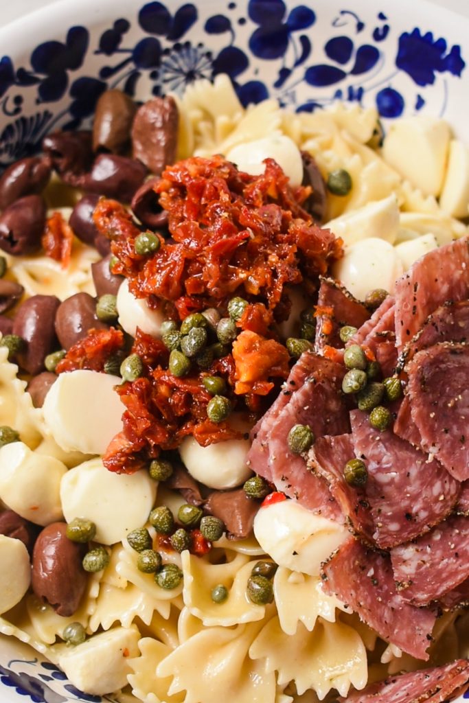 Pasta salad with all ingredients in the bowl except the dressing.