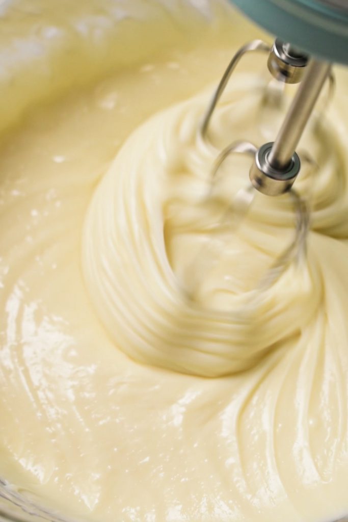 Using a hand mixer to beat together the condensed milk and cream cheese.
