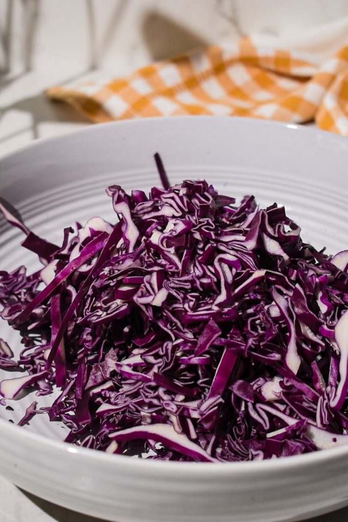 Chopped red cabbage in a white bowl.