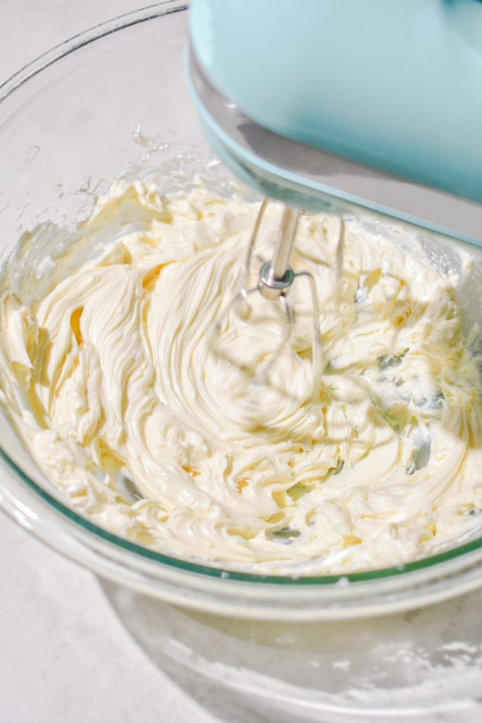 Whipping the cream cheese and powdered sugar together with a hand mixer.