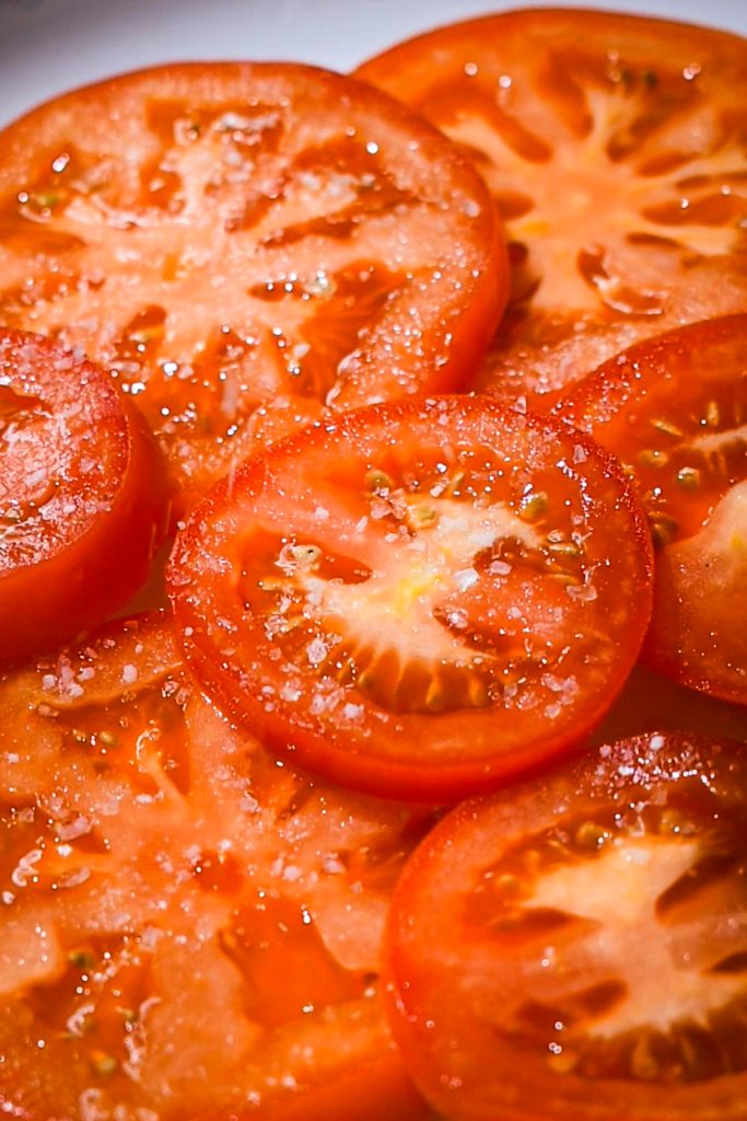 Sliced tomatoes with salt on top.