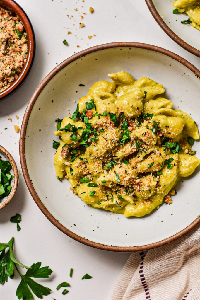 Beer cheese poblano macaroni and cheese served in a bowl and topped with parsley and toasted breadcrumbs.
