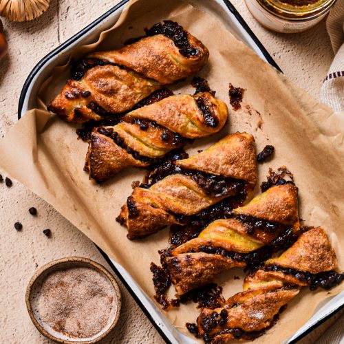 Overhead shot of pumpkin butter and chocolate chip twists on a small baking sheet lined with parchment paper.