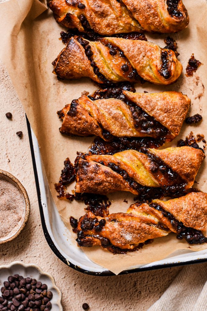 Overhead shot of pumpkin butter and chocolate chip twists on parchment paper.