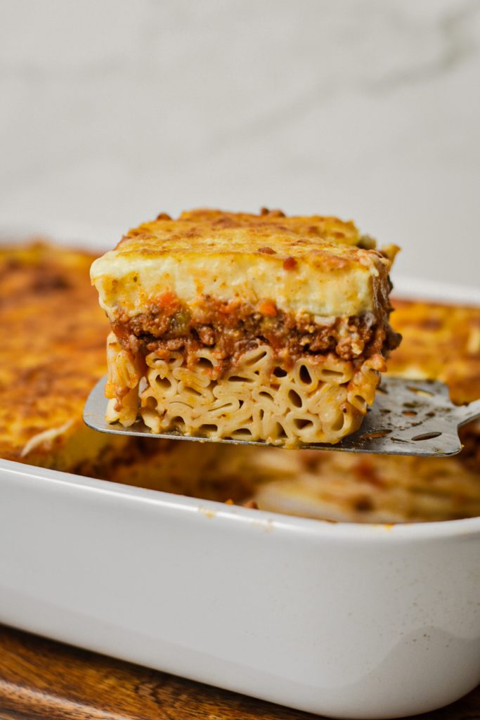 Slice of Greek pastitsio on a metal spatula.