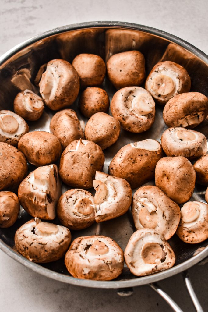 Whole mushrooms in a skillet.