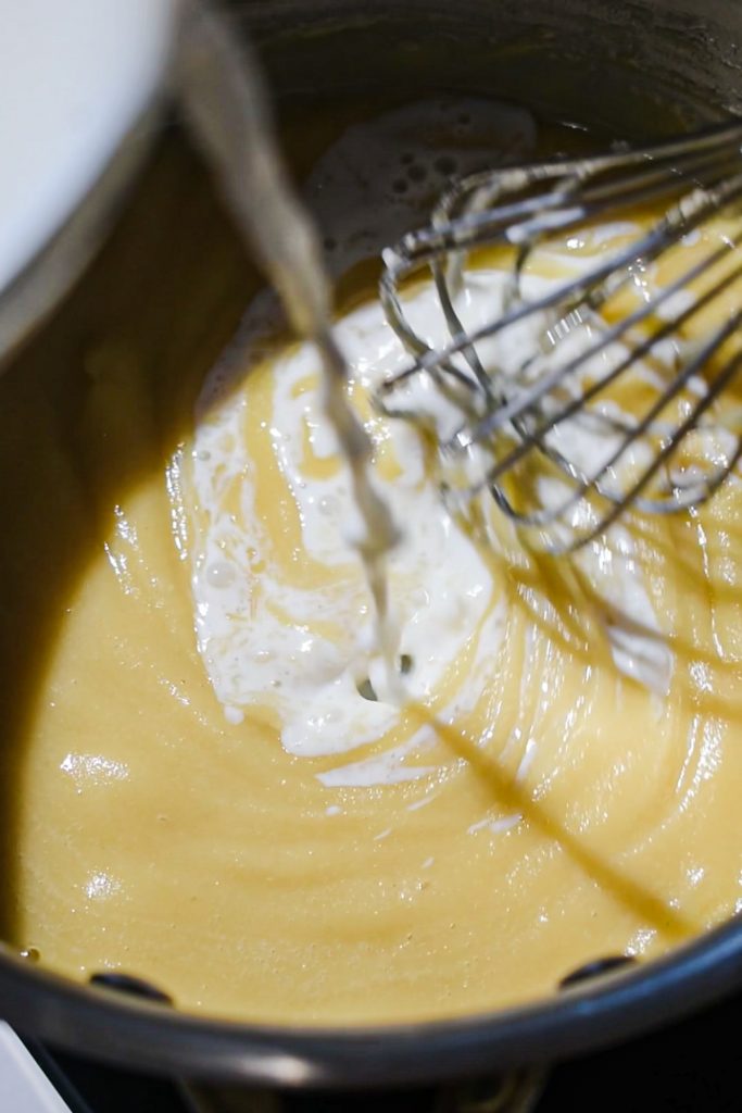 Milk being added to a roux made of butter and flour.
