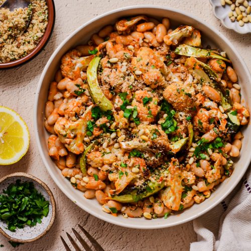 Overhead shot of roasted cauliflower and cannellini beans in a bowl.
