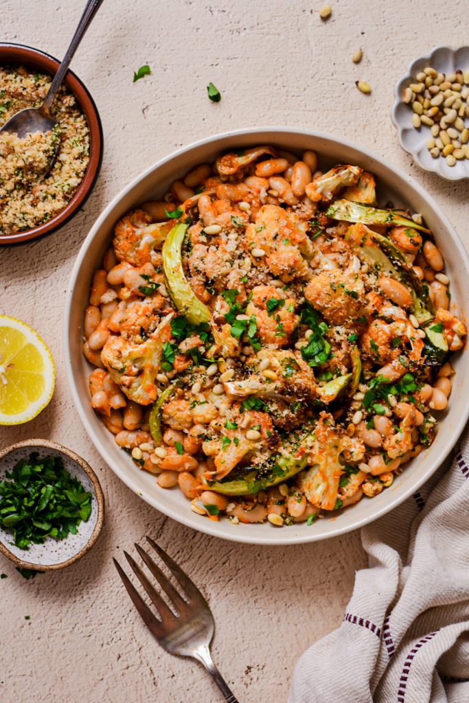 Overhead shot of roasted cauliflower and cannellini beans in a bowl.