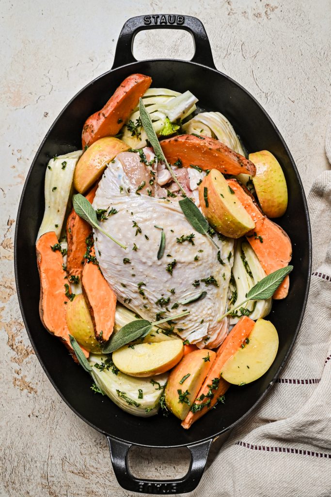 Overhead shot of the turkey breast with vegetables in a roasting pan before going into the oven.