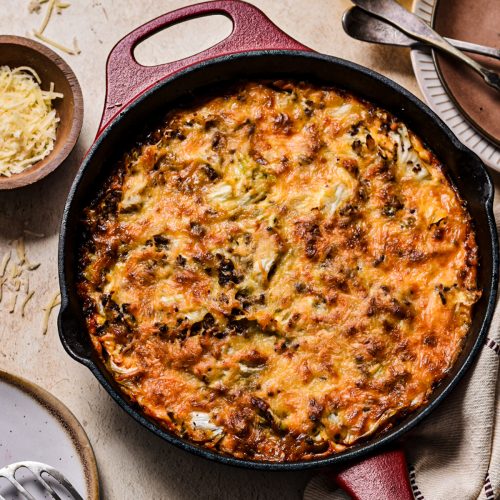 Baked ground beef and cabbage gratin in a red cast iron skillet.
