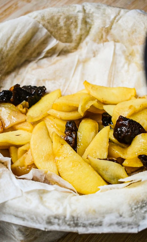 Apple and prune mixture in the phyllo dough in a baking dish.