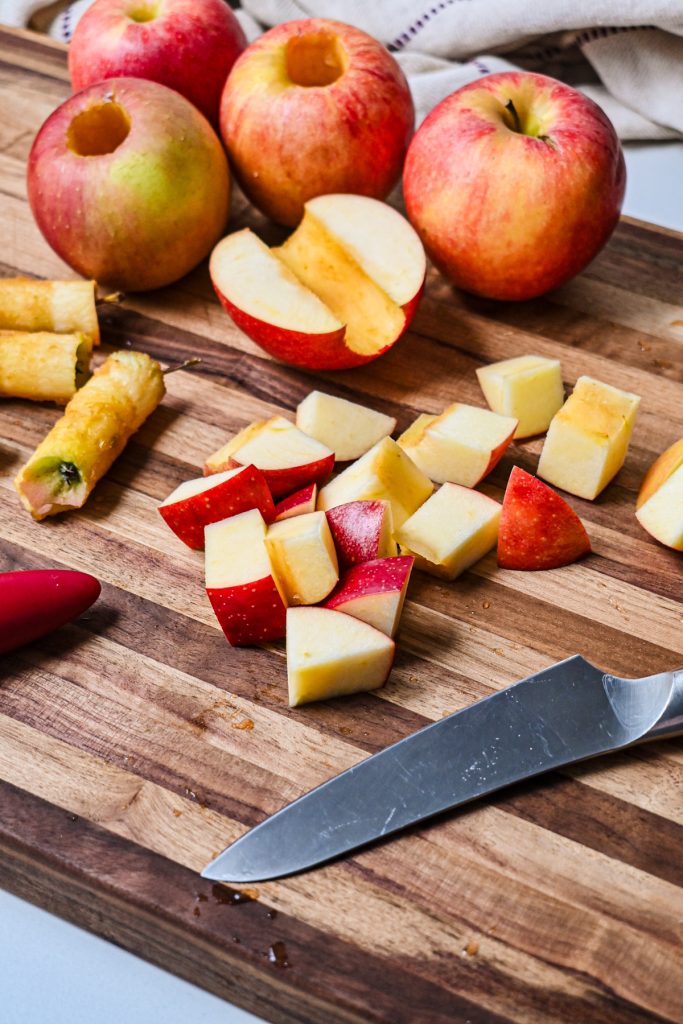 Cutting apples on a wooden board into cubes.