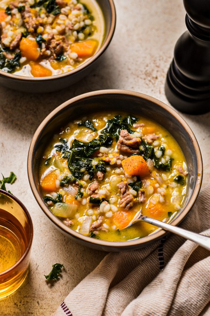 Two bowls of butternut squash, sausage, kale and barley soup.