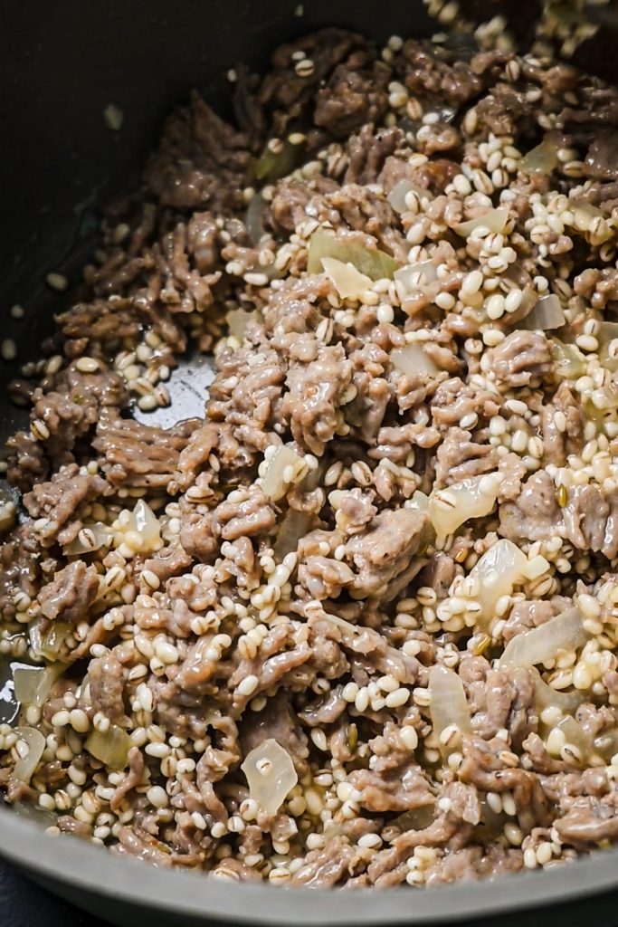 Pearled barley added to the pot of sausage and onions.