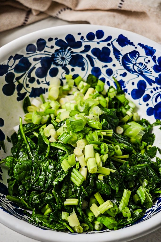 Scallions added to the bowl of spinach.