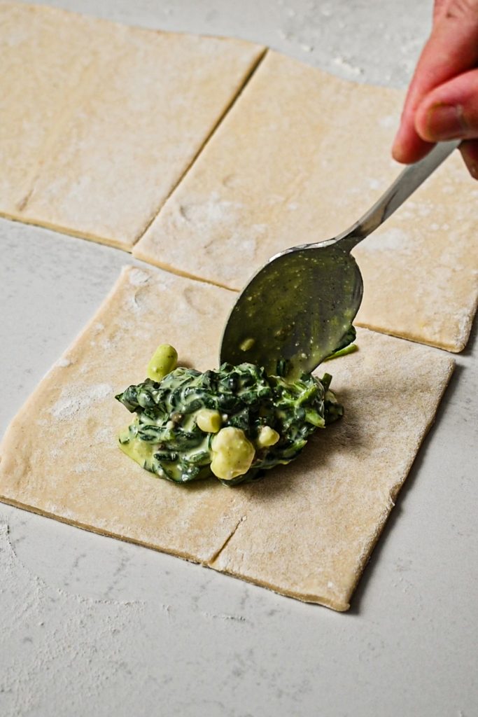 Spooning the filling into the puff pastry square.