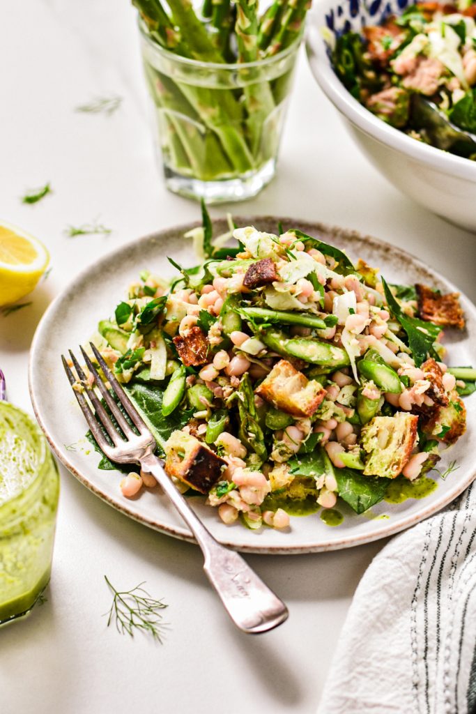 Large serving of asparagus white bean tuna salad served on a plate with a fork.