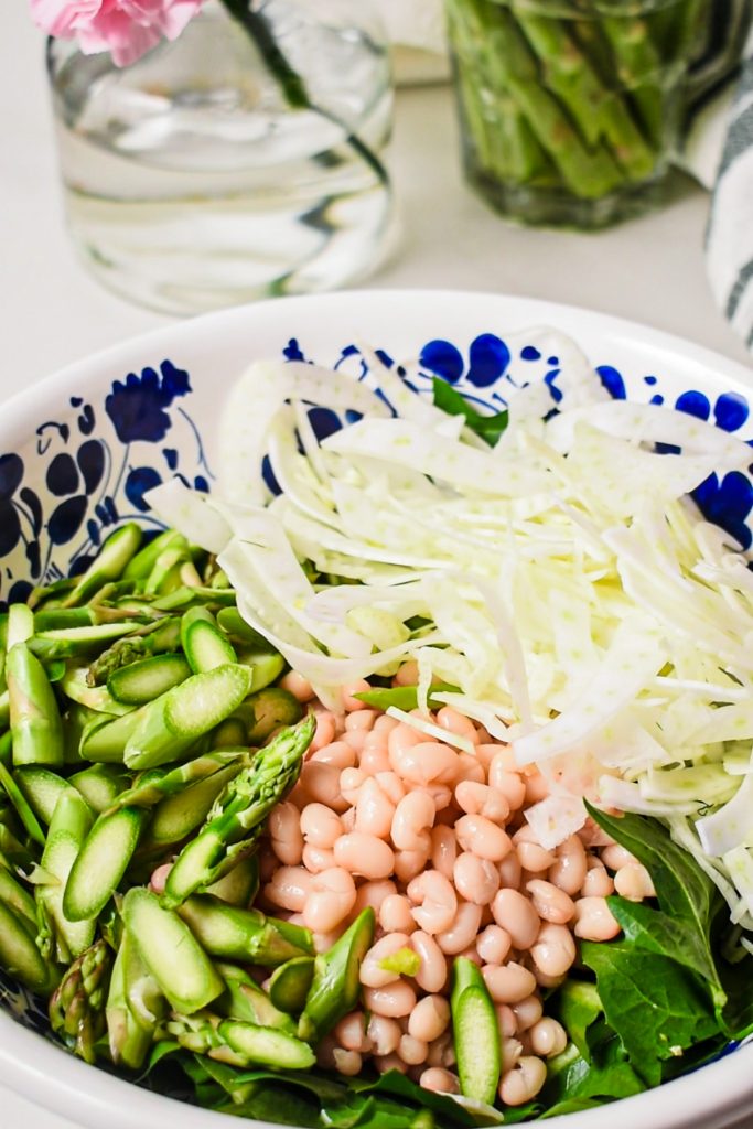 Sliced fennel added to the bowl with additional ingredients.