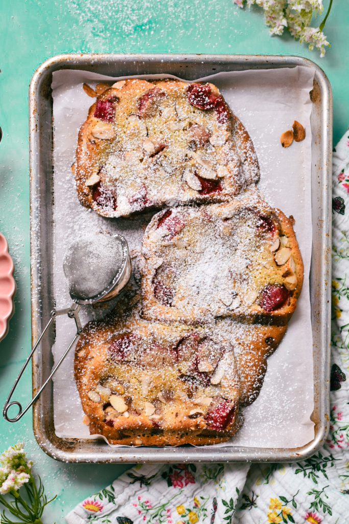 Overhead shot of bostock with rhubarb compote with powdered sugar on top.