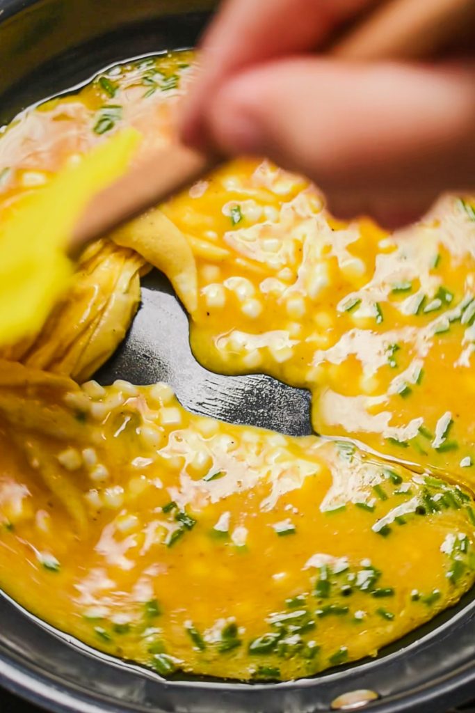 Cooking the eggs with cottage cheese in a skillet with a rubber spatula.