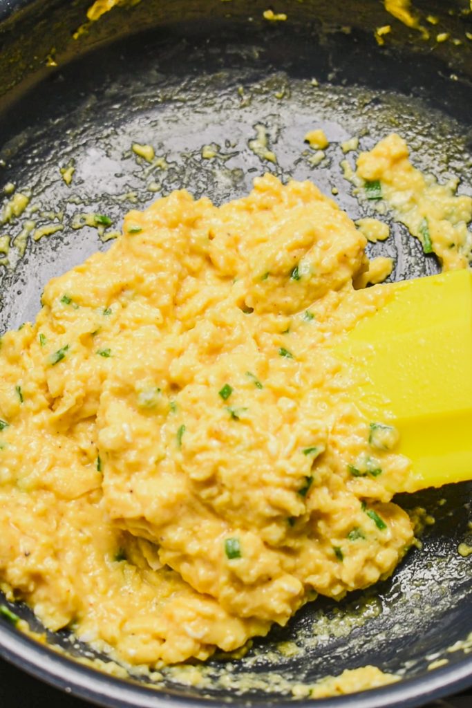 Softly cooked scrambled eggs with cottage cheese in a skillet.