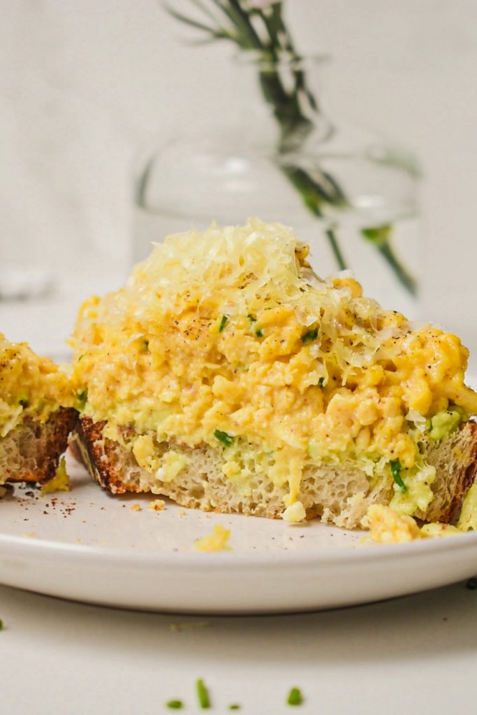 Creamy scrambled eggs with cottage cheese piled high on a piece of toast.