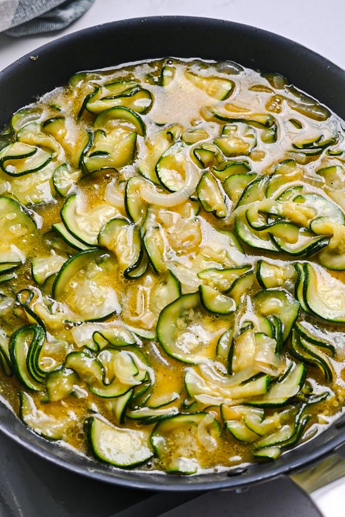 Egg and vegetable mixture in a skillet to cook.